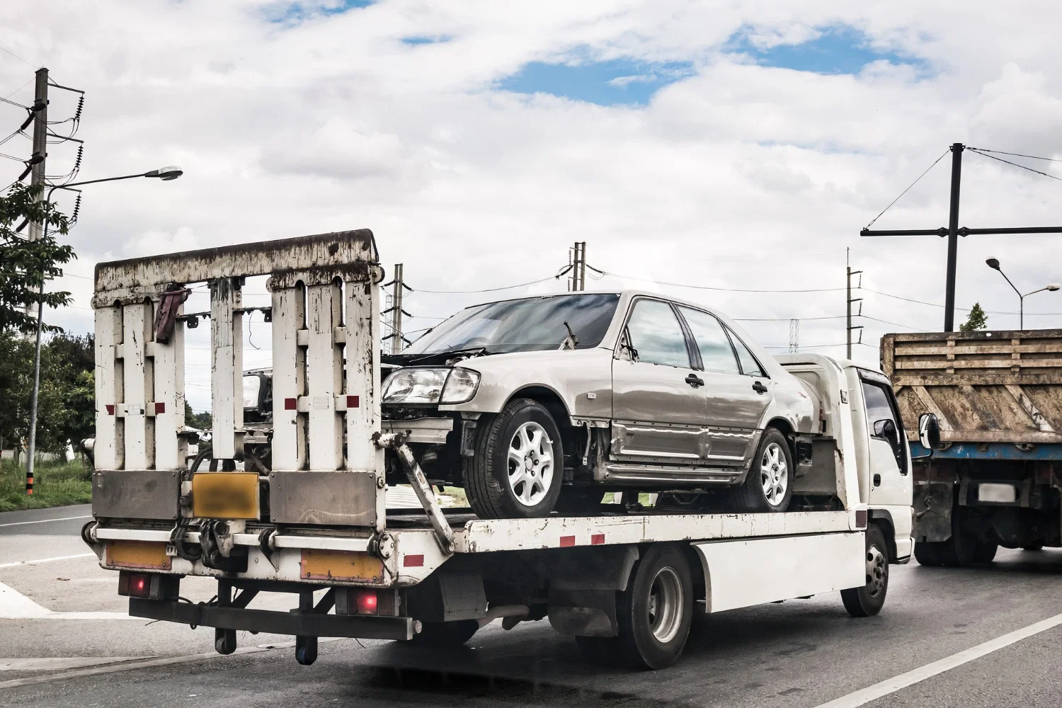Professional tow truck operator loading damaged vehicle near San Francisco